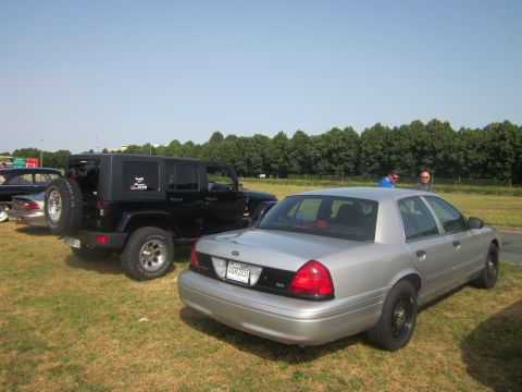 1991 Ford LTD Crown Victoria - Silver sedan parked on grass with a black Jeep nearby.