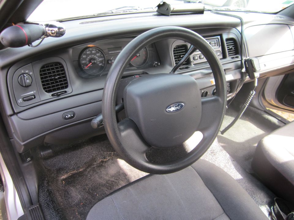 Interior view of a Ford Crown Victoria with a police radio and aftermarket equipment