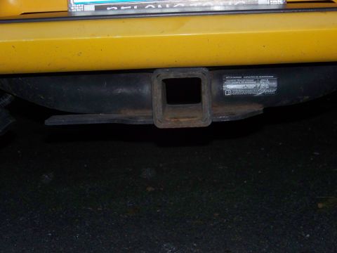 2005 Chevrolet Colorado - Trailer hitch receiver mounted on the rear of a yellow vehicle.