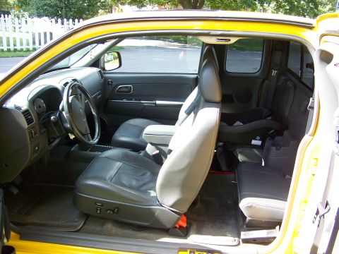 2005 Chevrolet Colorado - The interior of this yellow pickup truck features black leather seats and a child safety seat installed in the back.