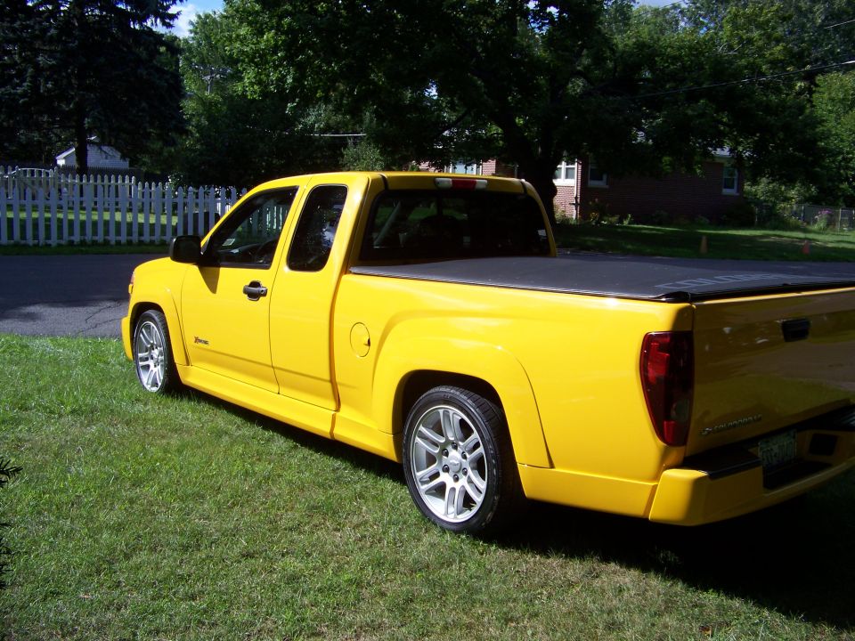 Yellow 2005 Chevrolet Colorado Xtreme pickup truck parked on grass, side view
