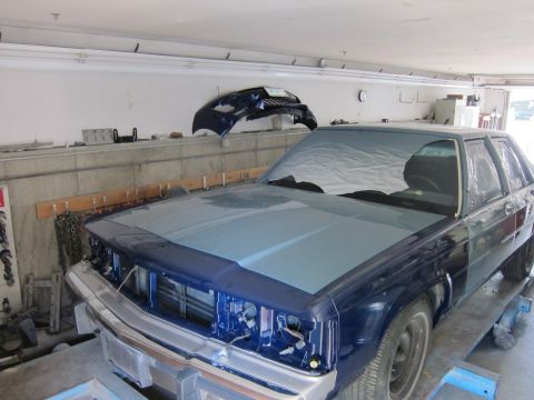 1991 Ford LTD Crown Victoria - Front view of a 1991 Ford Crown Victoria LTD in a repair shop, with the front end disassembled.