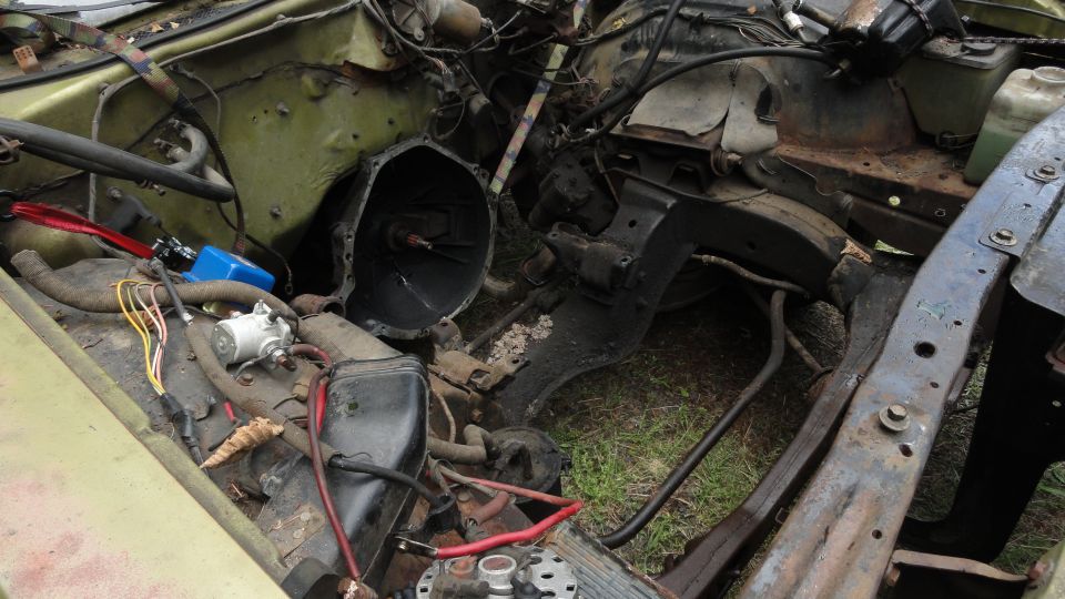 Car engine bay with transmission removed, showing engine block and frame