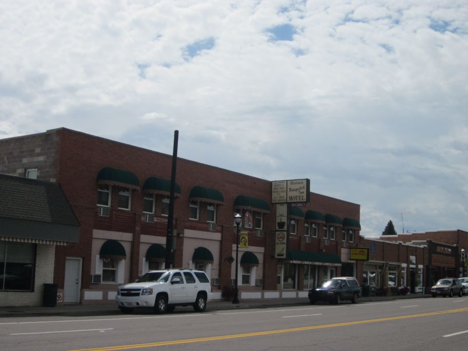 White SUV parked on street in front of a motel