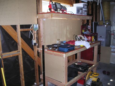 1997 Ford F-250 - A cluttered workbench in a garage setting, various tools and storage solutions.