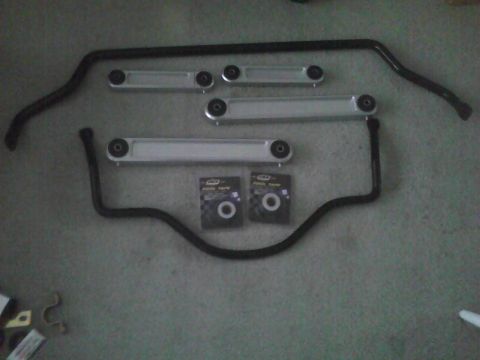 2003 Ford Crown Victoria - A collection of automotive suspension components, including sway bars and bushings, are displayed on a floor.