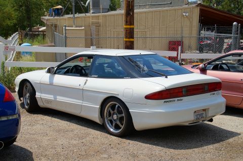 1993 Ford Taurus - A white Ford Probe GT is parked next to a pink car, with a blue car partially visible on the left.