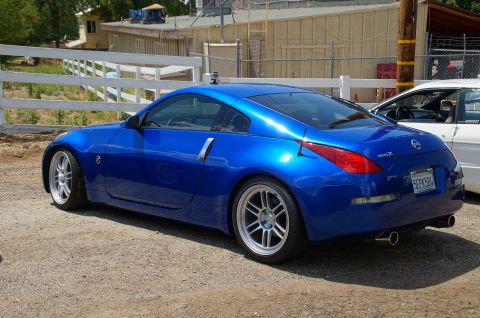 1993 Ford Taurus - Blue Nissan 350Z coupe with aftermarket wheels and exhaust parked outdoors.