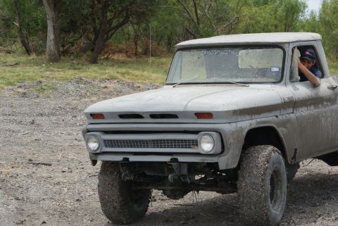 1989 Ford Bronco - A 1964 Chevrolet C10 pickup truck with large off-road tires is seen from the front.