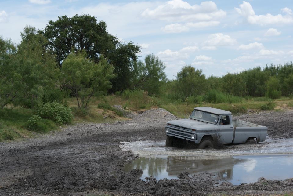 Gray 1966 Chevrolet C10 pickup truck stuck in a mud puddle off-road