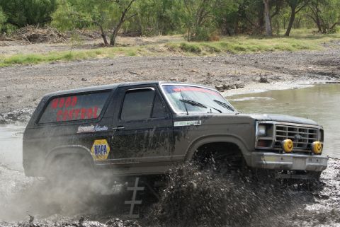 1989 Ford Bronco - This 1989 Ford Bronco navigates a muddy off-road course, kicking up a significant spray.