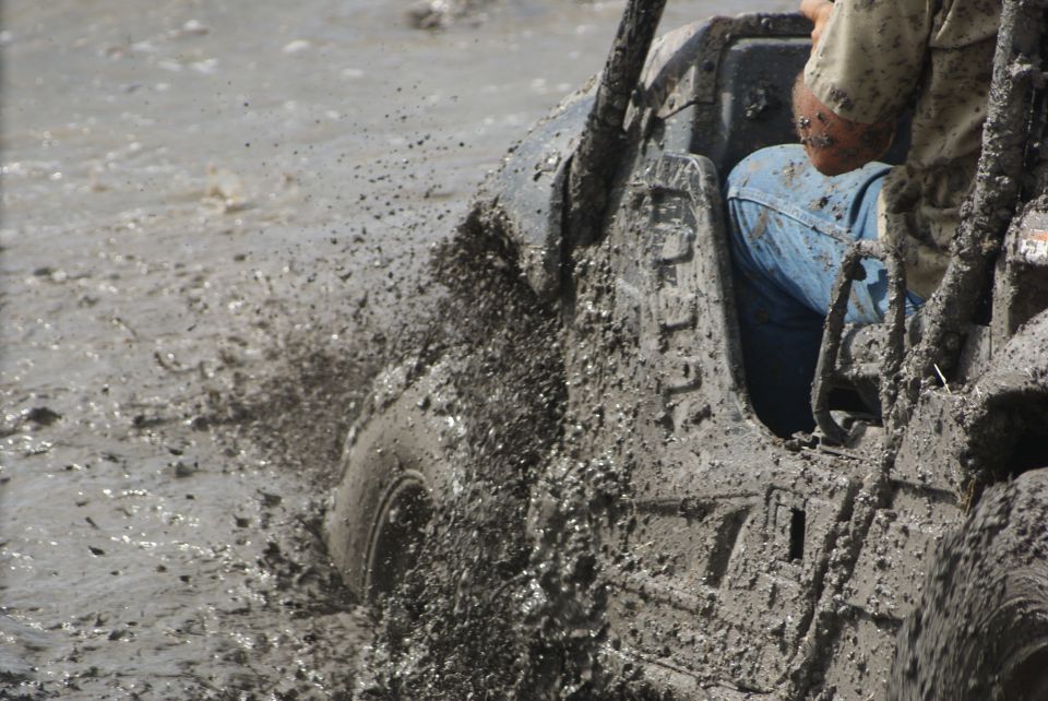 Off-road vehicle splashing through mud, side view