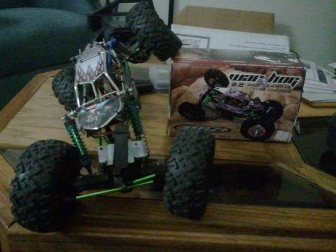 1985 Ford Bronco - A remote control rock crawler toy is shown next to its product box on a wooden surface.