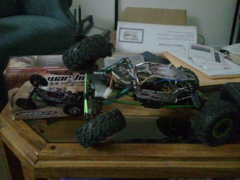 1985 Ford Bronco - A remote-controlled rock crawler toy sits on a table, partially assembled, with its packaging nearby.
