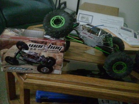 1985 Ford Bronco - A radio-controlled rock crawler toy sits on a wooden table next to its product box.