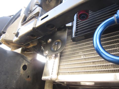 2008 Jeep Wrangler - Close-up view of the engine bay, highlighting the radiator, a blue tow hook, and custom mounting brackets.