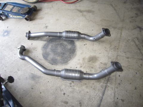 2008 Jeep Wrangler - Two new exhaust pipes with catalytic converters are ready for installation.
