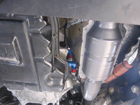 2008 Jeep Wrangler - This image shows the undercarriage of a vehicle, focusing on the transmission and exhaust components, including a catalytic converter.