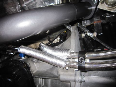 2008 Jeep Wrangler - Close-up view of engine components, including silver-wrapped hoses and a large grey pipe, likely part of an aftermarket modification.