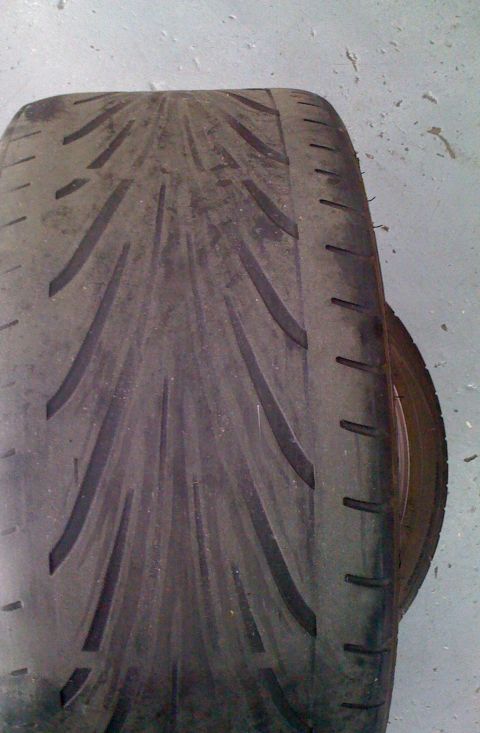 1990 Ford Probe - A close-up view of a worn tire, showing its tread pattern and sidewall details.