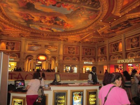 1991 Ford LTD Crown Victoria - An interior view of a casino lobby, elaborate decor, shops, and people.