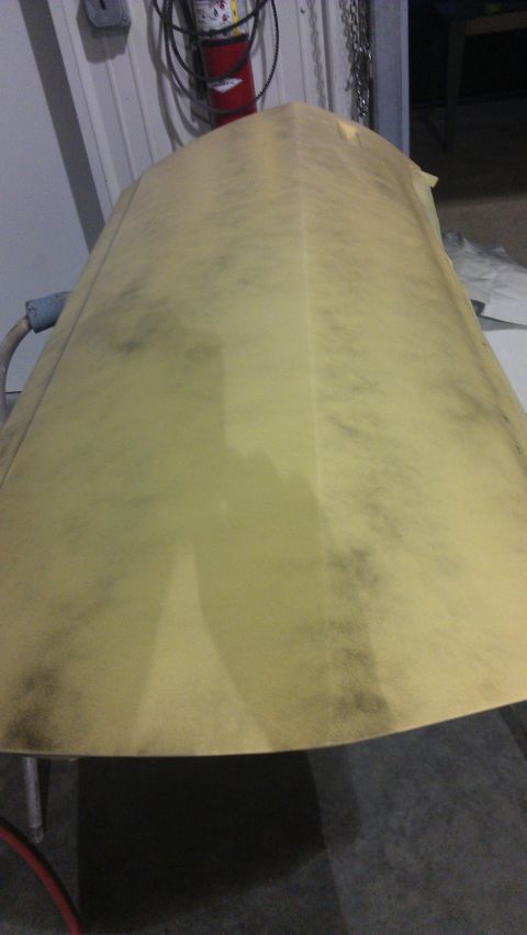 1973 Chevrolet Camaro - A car hood is covered in a yellow protective material, showing dark smudges.