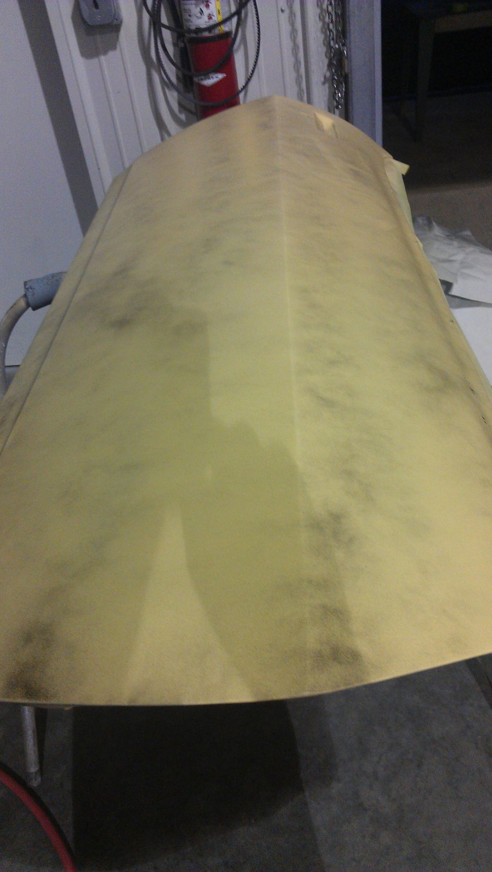 Yellow car hood with dark smudges, angled view