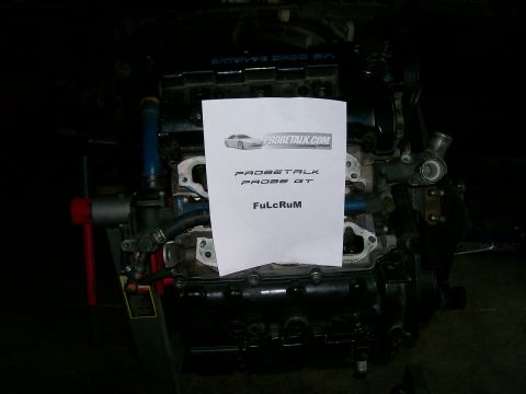 1995 Ford Probe - Engine block with a paper that has PROBETALK.COM and PROBE GT printed on it.