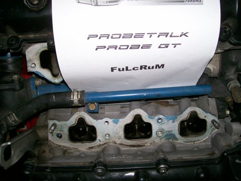 1995 Ford Probe - Close-up of an engine manifold with a paper displaying text related to a Ford Probe GT.