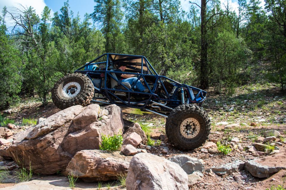 Custom off-road buggy with a roll cage navigating a rocky trail