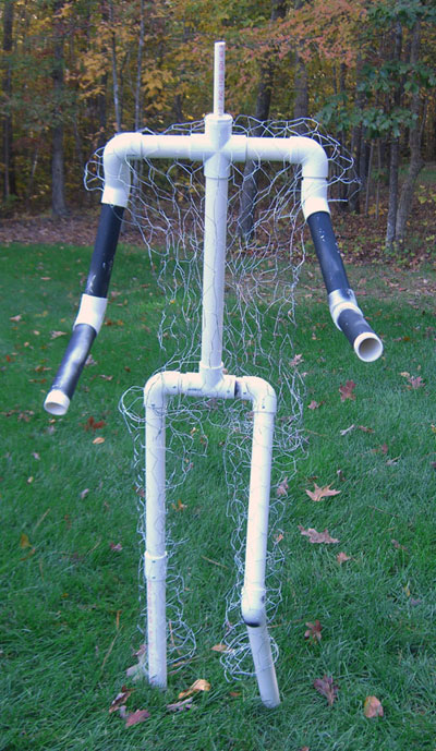 1989 Ford Bronco - A frame constructed from PVC pipes and chicken wire, intended to be a scarecrow, stands on a lawn with autumn trees in the background.