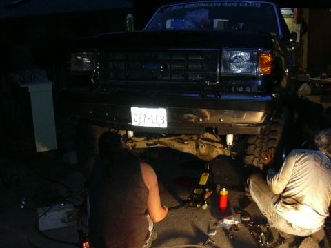 1991 Ford Bronco - Mechanics work on the front suspension of a 1991 Ford Bronco during a lift kit installation.