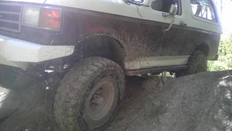 1989 Ford Bronco - This vehicle is covered in mud from off-roading on a dirt trail.