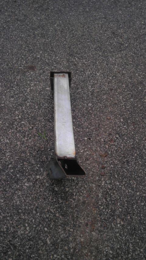 1989 Ford Bronco - A metal bracket is shown on an asphalt surface, with no visible vehicle information.