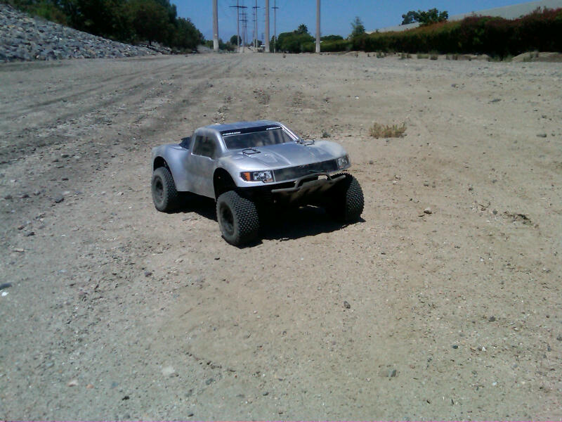 Silver remote control truck on a dirt road