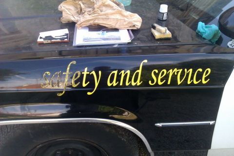 1991 Ford LTD Crown Victoria - Car fender displays "safety and service" text; items are on the hood.