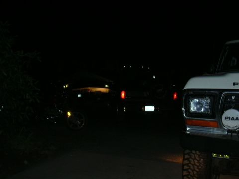1991 Ford Bronco - A lifted 1979 Ford F-Series truck is parked at night, with another vehicle in the background.
