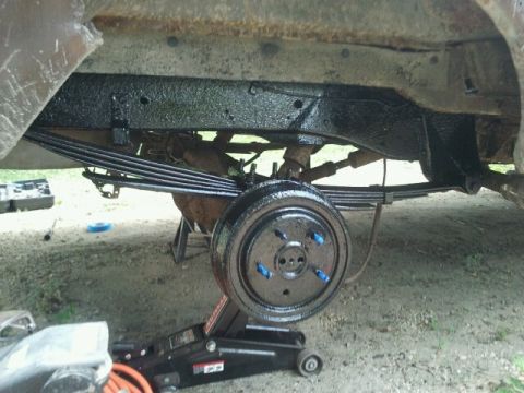 1979 Ford Bronco - Close-up of a vehicle's rear axle assembly with leaf springs and drum brake.
