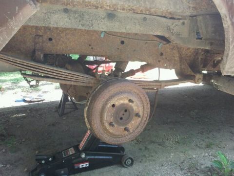 1979 Ford Bronco - The vehicle's rear suspension and axle are heavily rusted and appear to be undergoing maintenance.