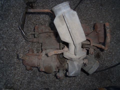 1987 Ford Ranger - A rusty carburetor assembly, likely from an older vehicle, is shown against a gravel background.