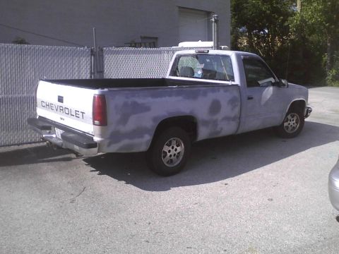 2003 Ford Crown Victoria - Chevrolet pickup truck with primer finish is parked outdoors.