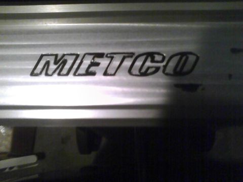 2003 Ford Crown Victoria - Close-up of the METCO logo on a metallic component.