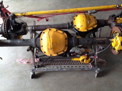 1988 Ford Bronco - Two differential axles, likely from a 4x4 vehicle, are mounted on a metal cart for repair or transport.