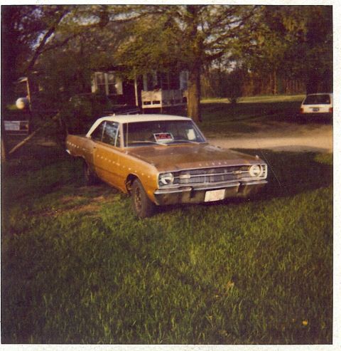 1988 Ford Bronco - A gold 1967 Dodge Dart GT with a white roof sits on a grassy lawn next to a house, with another vehicle visible in the background.
