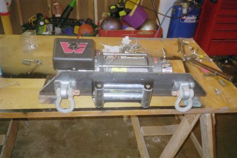1988 Ford Bronco - A winch assembly, likely for off-road use, is shown mounted on a metal plate with shackles attached.