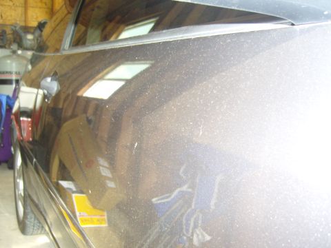 2007 Ford Mustang - Side view of a car's exterior, showing dust accumulation on the door and window.