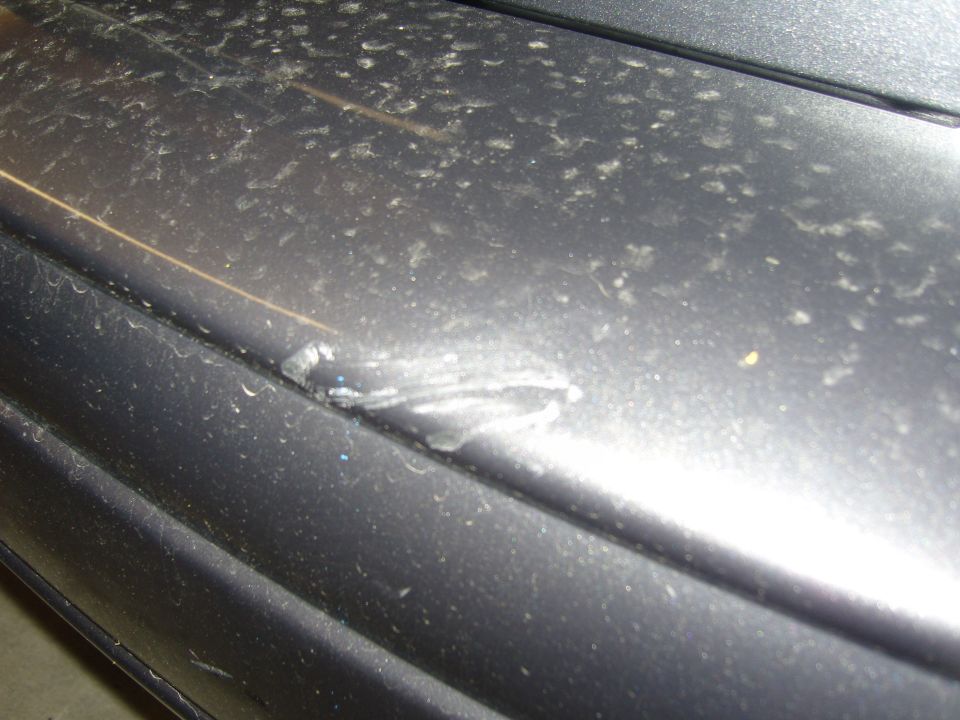 Dark gray bumper with a dent and scuff marks