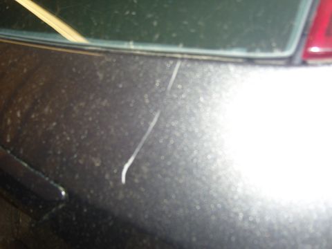 2007 Ford Mustang - A close-up view of a scratched car body panel, likely the rear quarter panel.