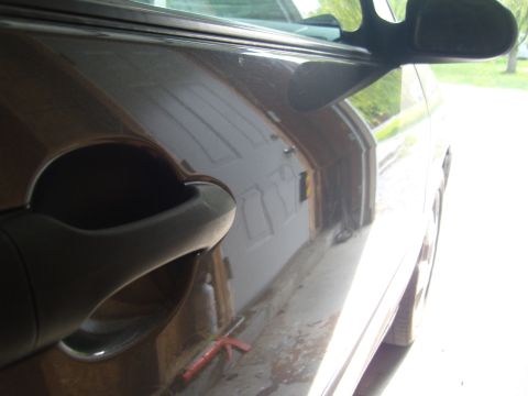 2007 Ford Mustang - Close-up of a car's side door handle and side mirror, reflecting a garage door.