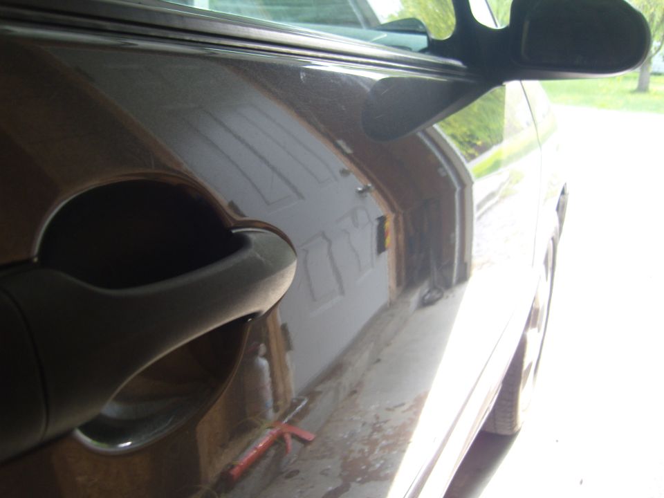 Dark brown car door handle and side mirror, side view